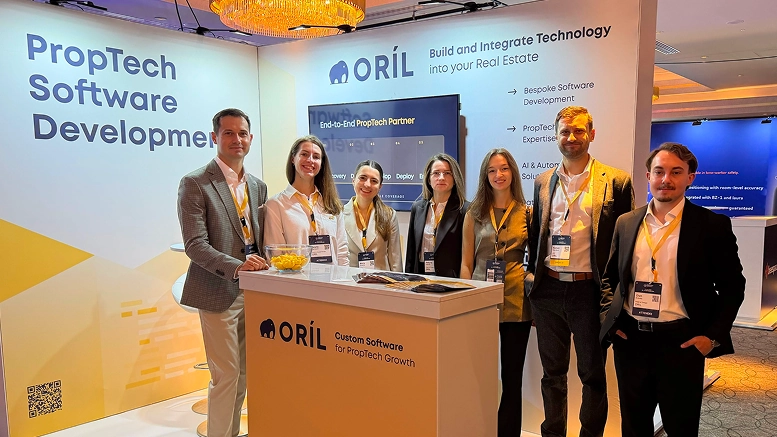 Team members at ORIL | custom software development company showcase PropTech solutions at a professional event booth.